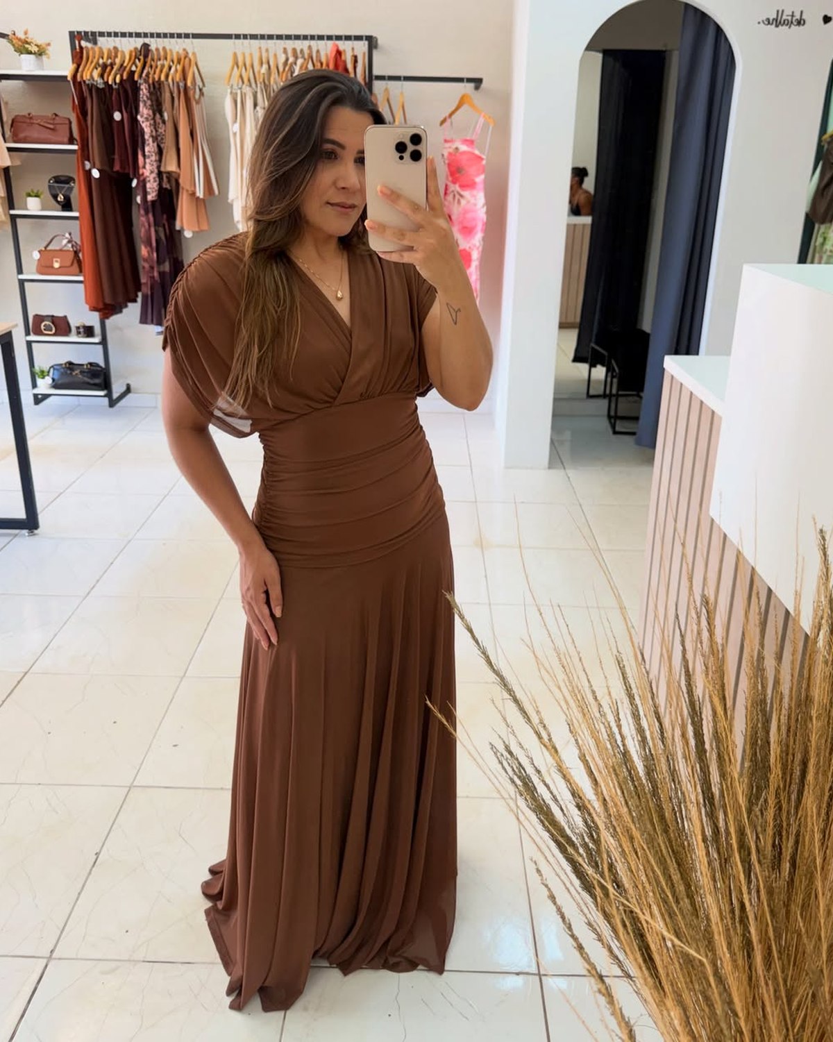 Kelly vestindo um vestido longo marrom na loja Varal Chic